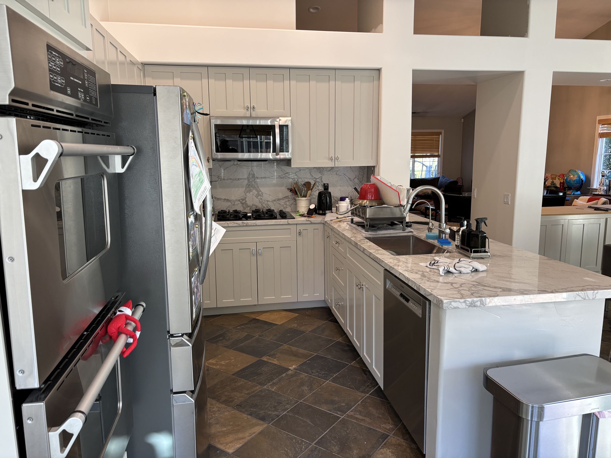 Gray-painted shaker kitchen cabinets with a marble backsplash in Santa Ynez, CA