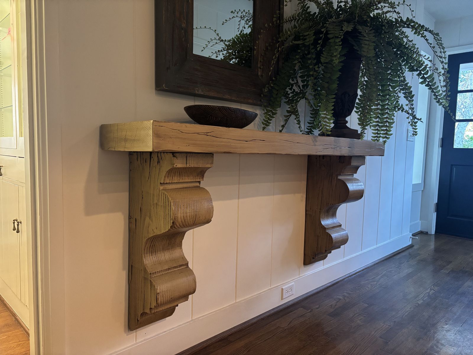 Rustic wood console shelf on carved corbels in a Los Olivos, CA entryway